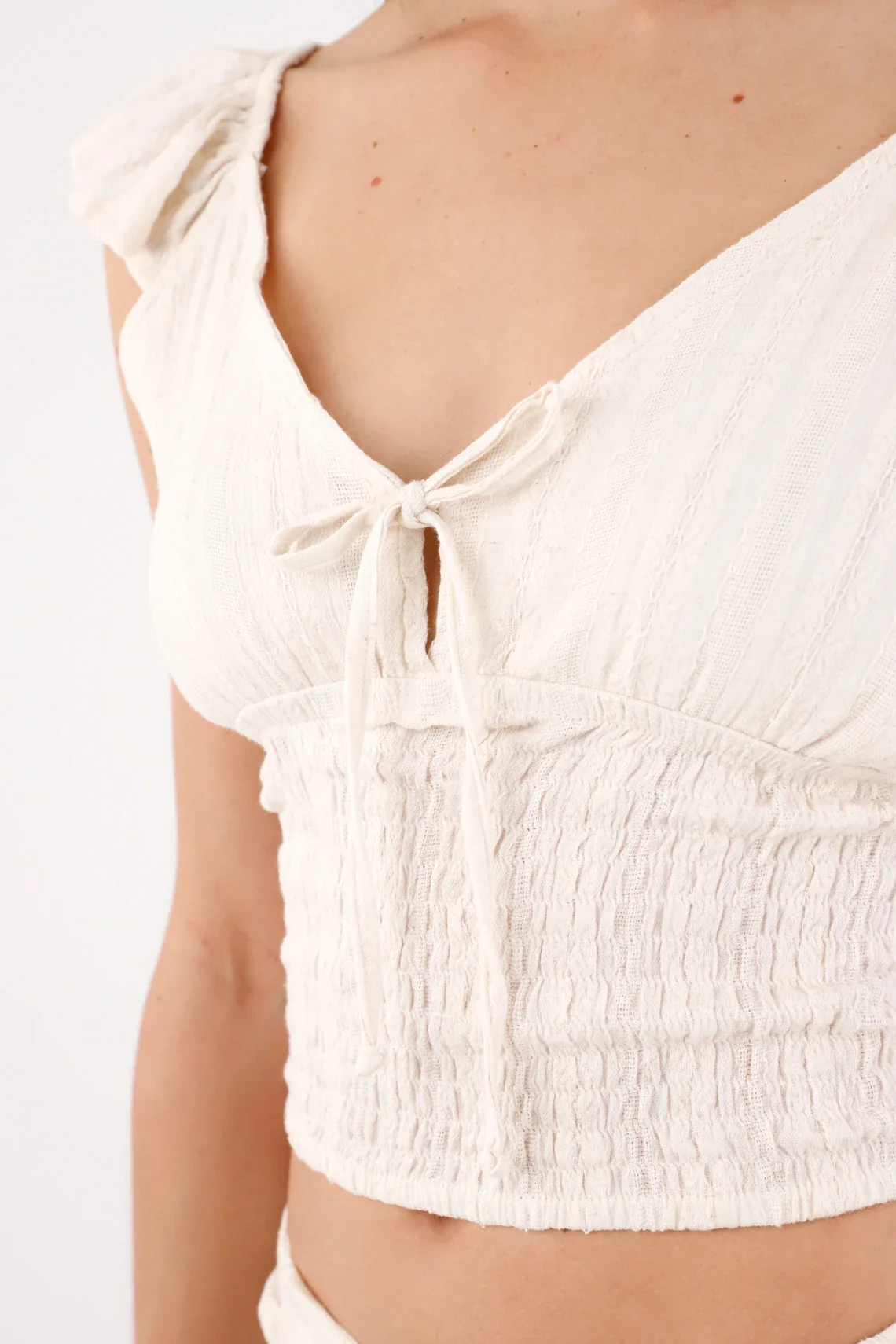 Fitted cropped blouse with bow and smocking in off-white cotton for women - Image 3